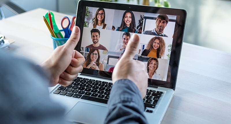 back-view-male-employee-making-gesturing-approval-with-thumb-fingers-while-speak-video-call-with-diverse-colleagues-online-briefing-with-laptop-home